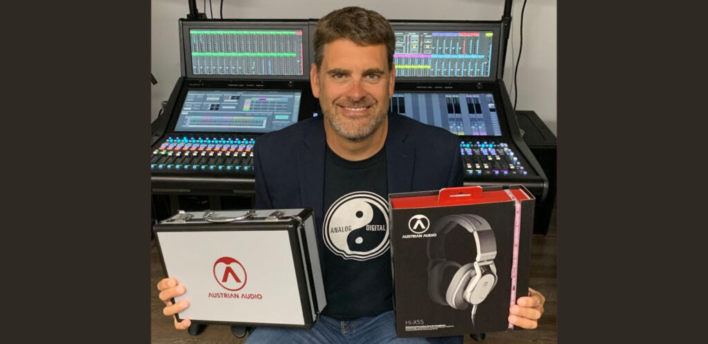 Bryan Bradley President of Group One holds HiX-55 headphones.